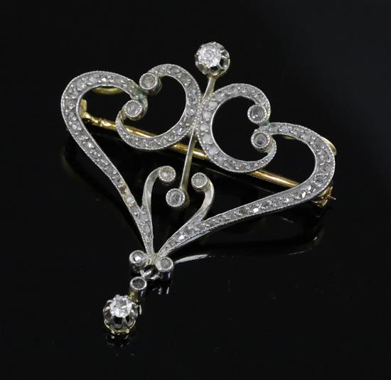 A French Belle Epoque 18ct gold and diamond set openwork scroll drop pendant brooch, 38mm.